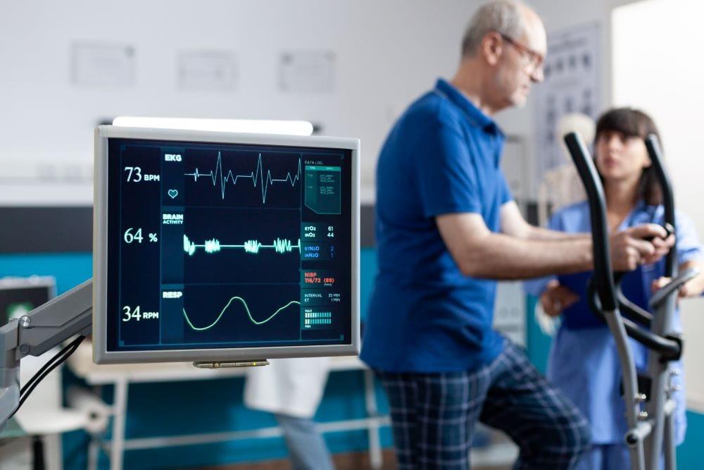Physiotherapist guiding patient through cardiopulmonary rehabilitation breathing exercises at home